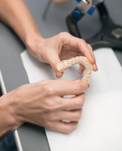 Close up picture hands with dental prosthesis Close up picture hands with dental prosthesis